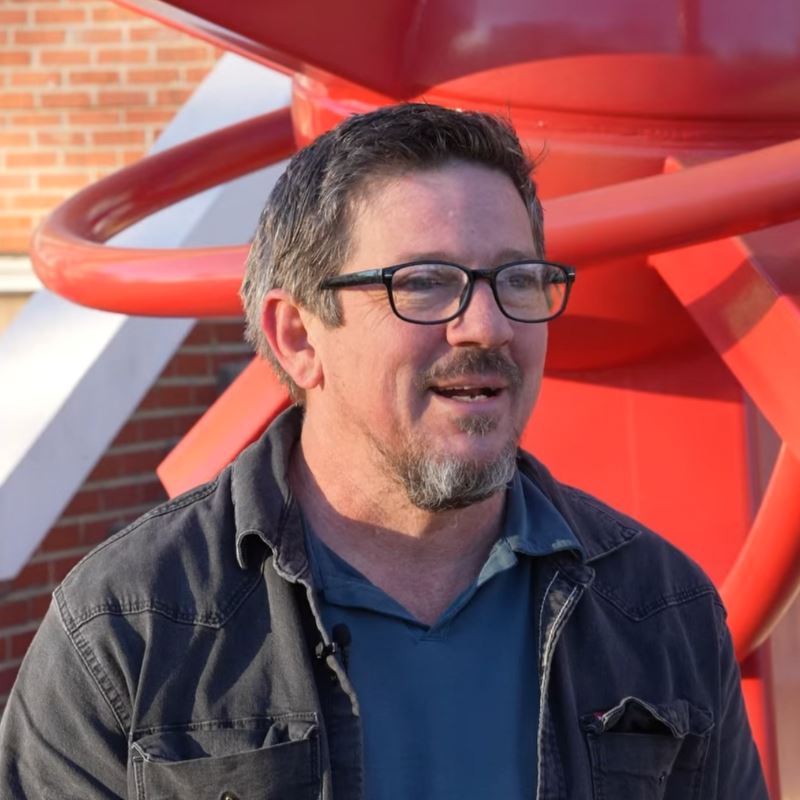 Nathan Pierce stands in front of his sculpture don't forget us