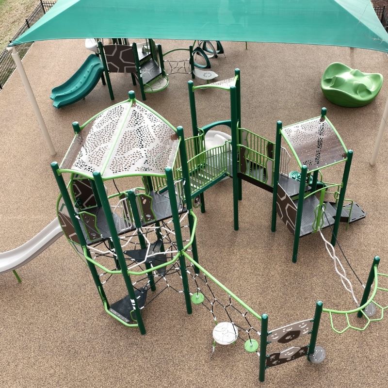 Parks and Rec Director Todd Riddick speaks at podium in front of playground