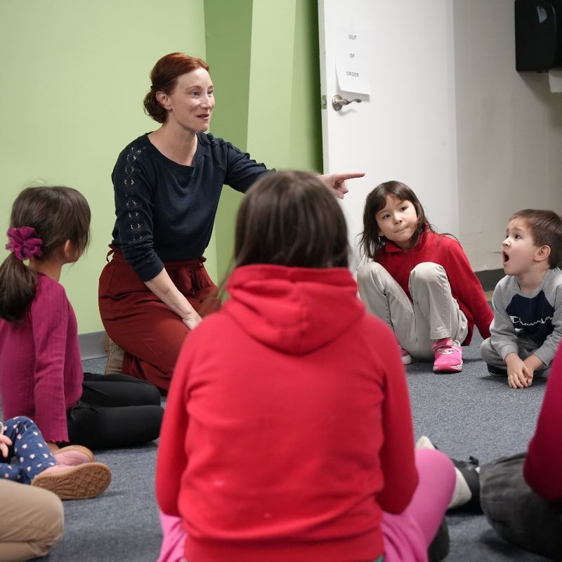 children sit in a circle as teacher Tanya Quinn tells a story