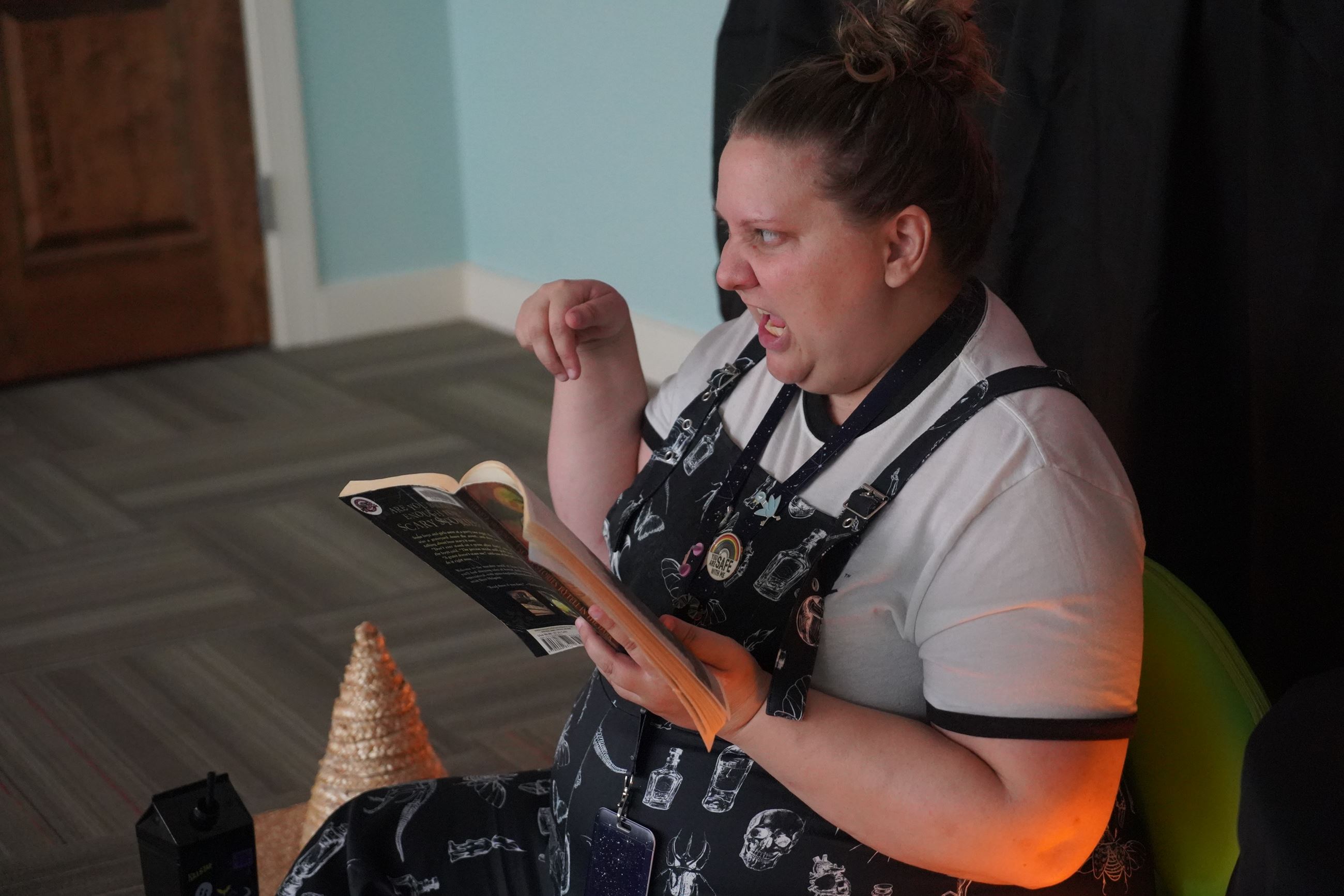 Grace Davis reads a scary book during All Hallows Read