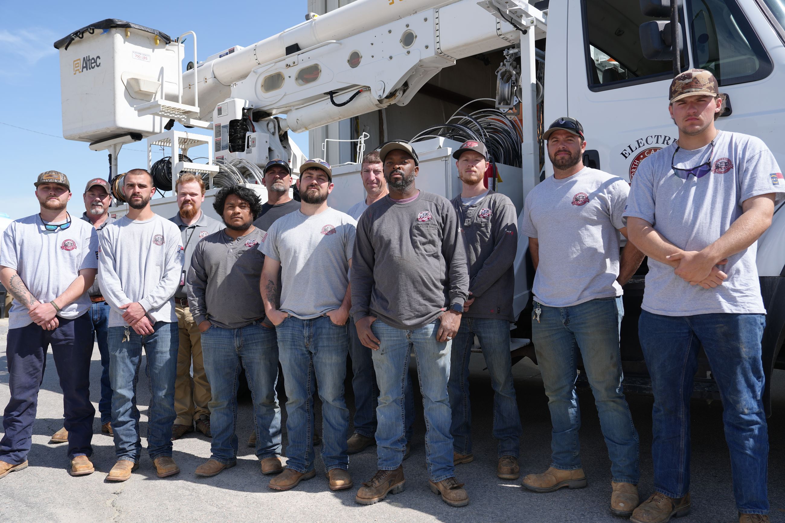 Town of Clayton Electric Department pose for photo in from of bucket truck