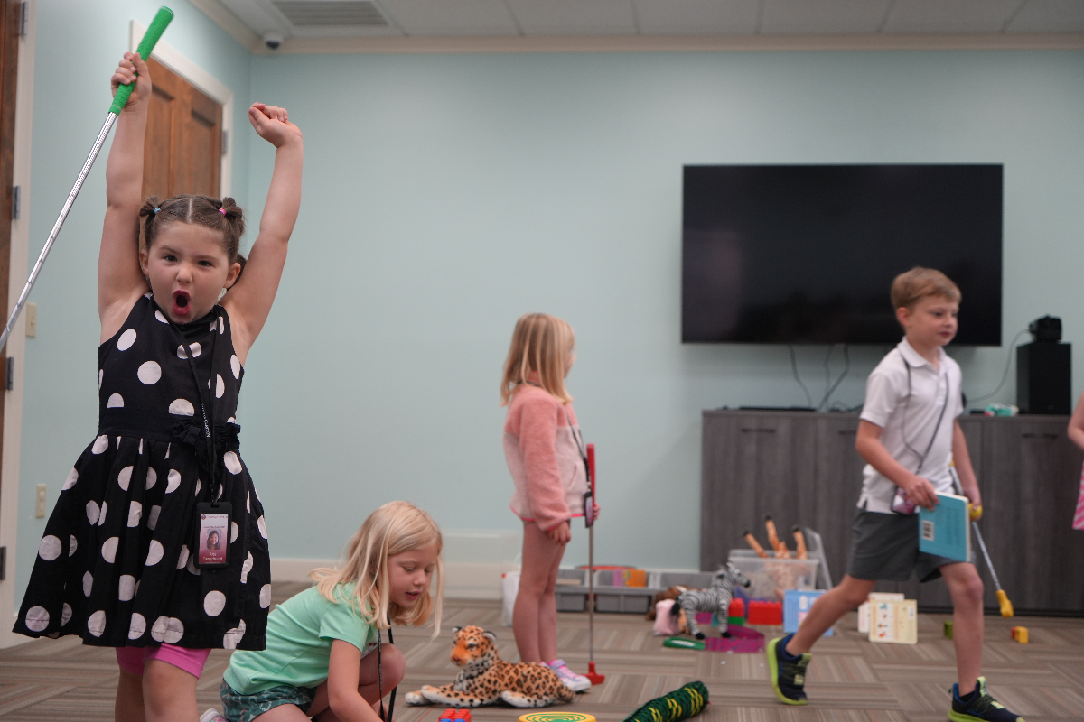Girl celebrates after landing golf ball into hole