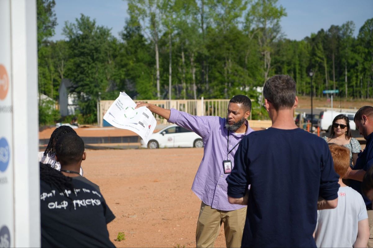 Kids standing near work site with Inspections Director explaining  the process