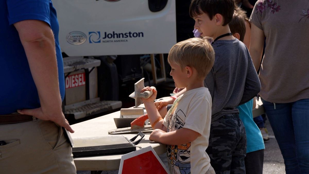 Kid holds tool used by the Public Works Department