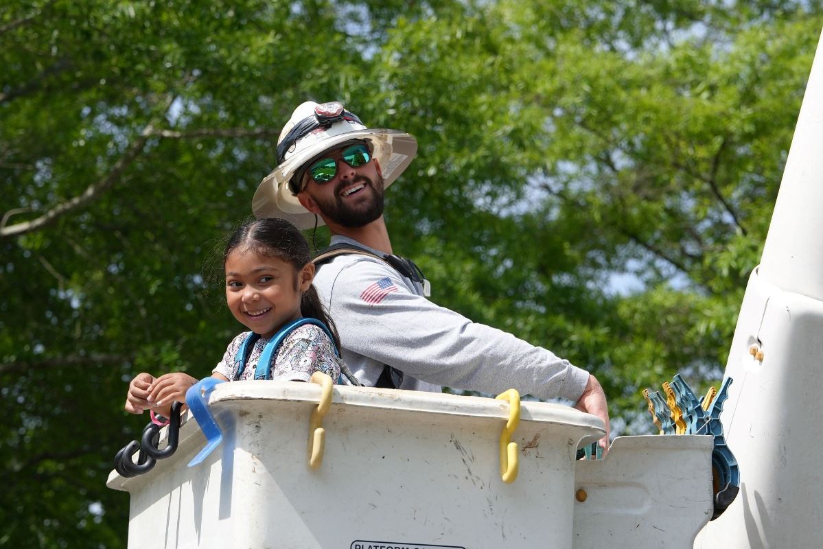 Lineman takes little girl up in bucket truck