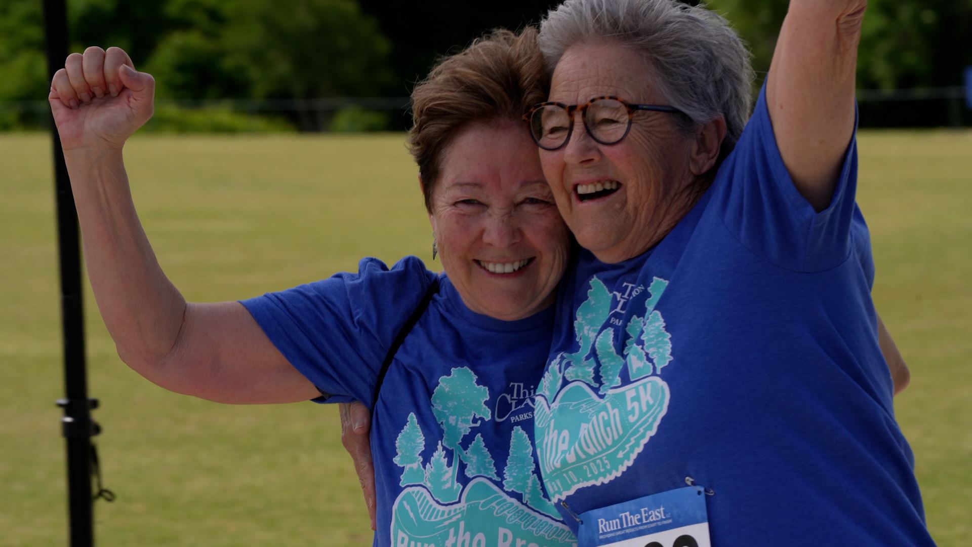 Participants Hug and Smile While Crossing the Finish Line